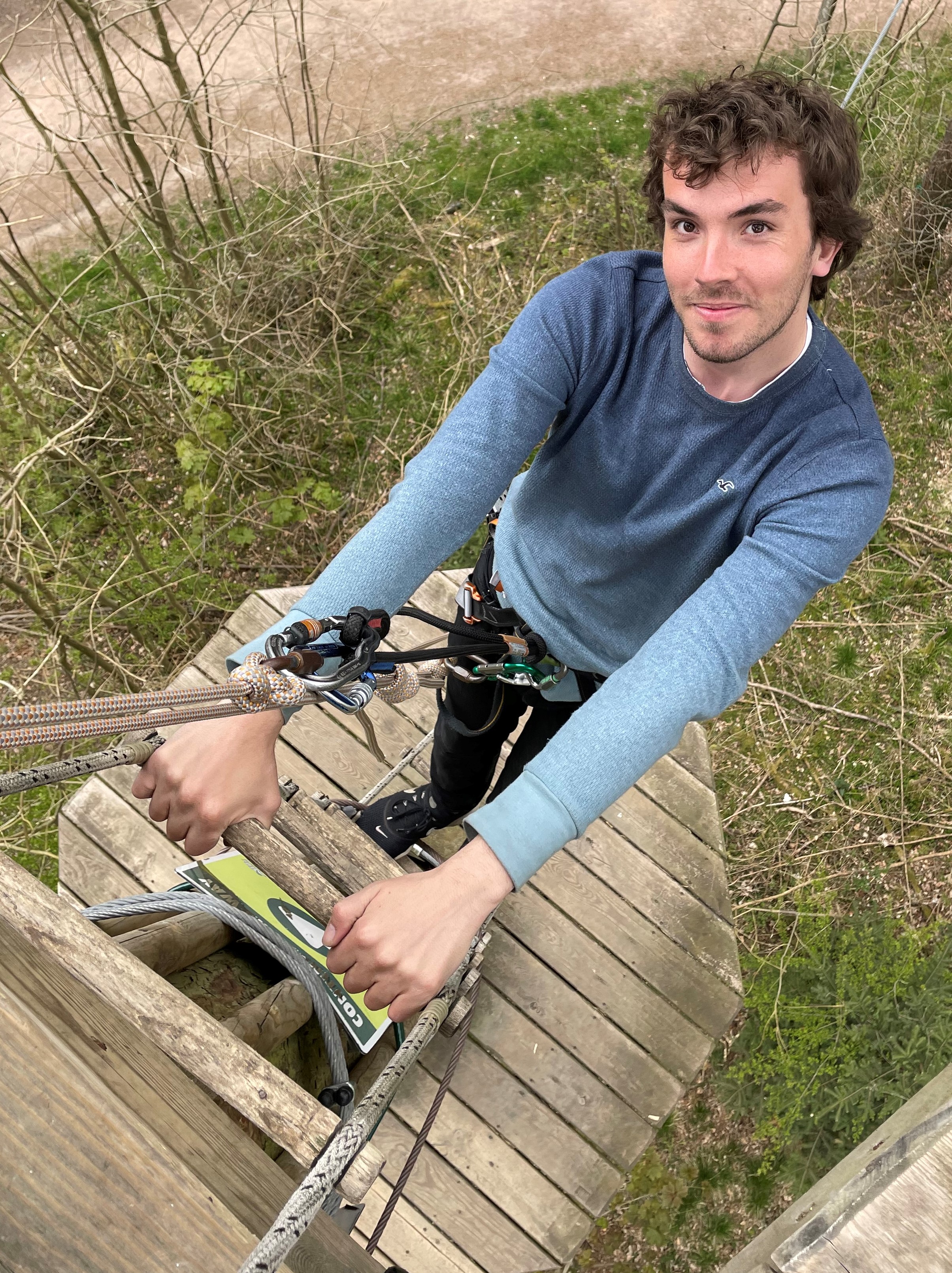 Go Ape instructor Will Moore climbing a ladder on Treetop Challenge 