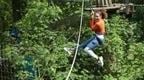A woman in a Go Ape Treetop Challange high ropes adventure course