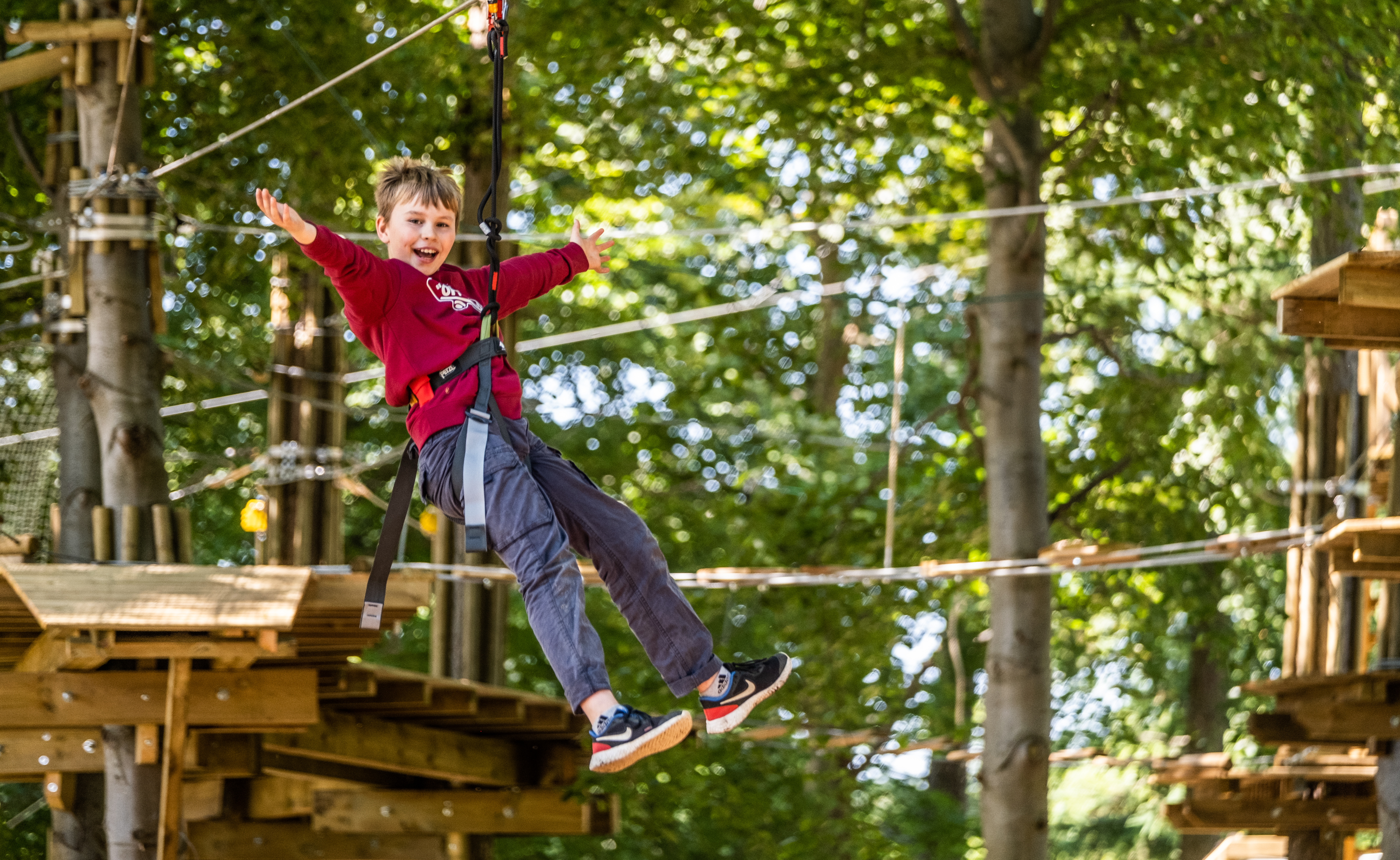 Boy in red on Treetop Adventure crossing