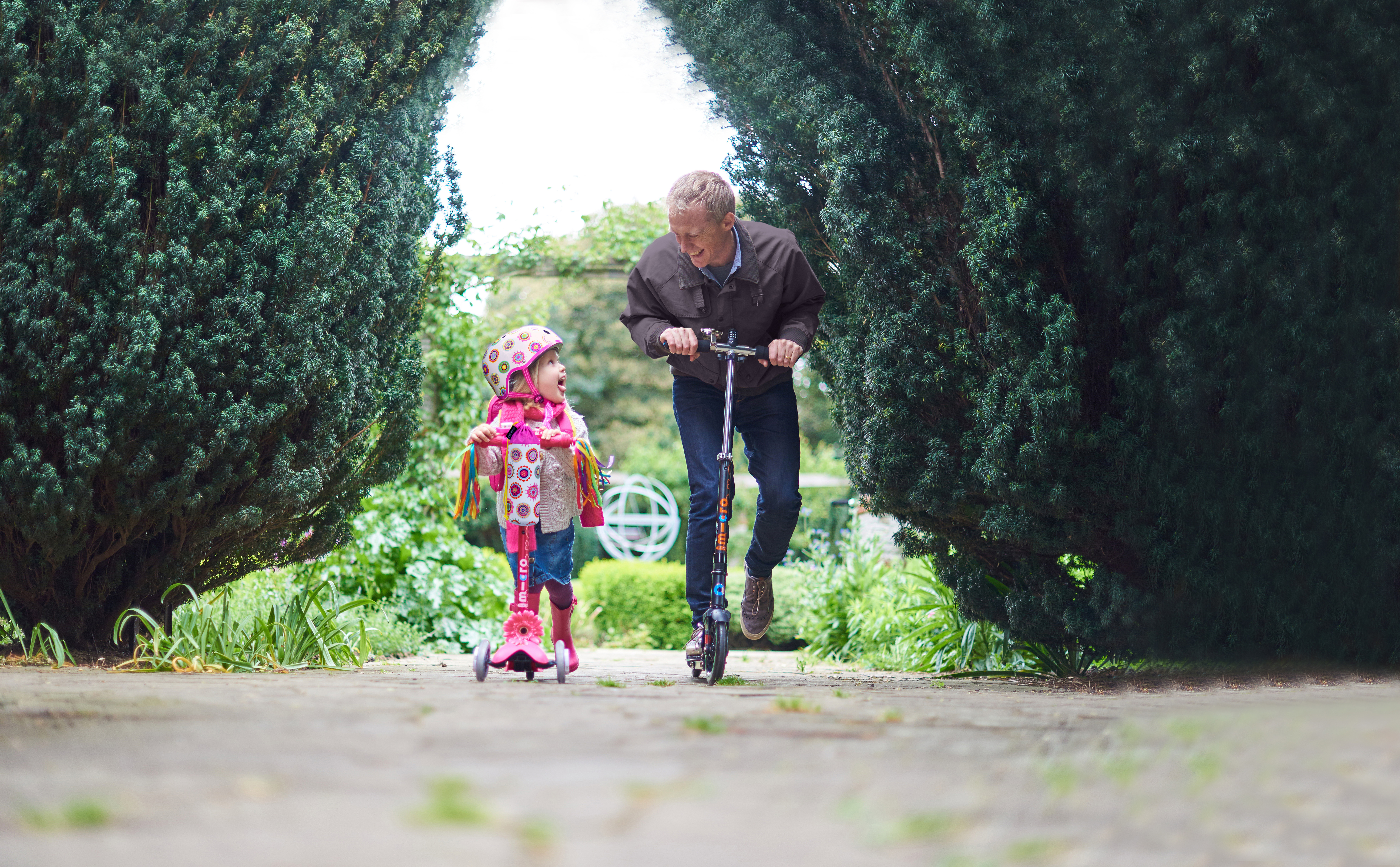 Grandfather and grandaughter on micrscooters 