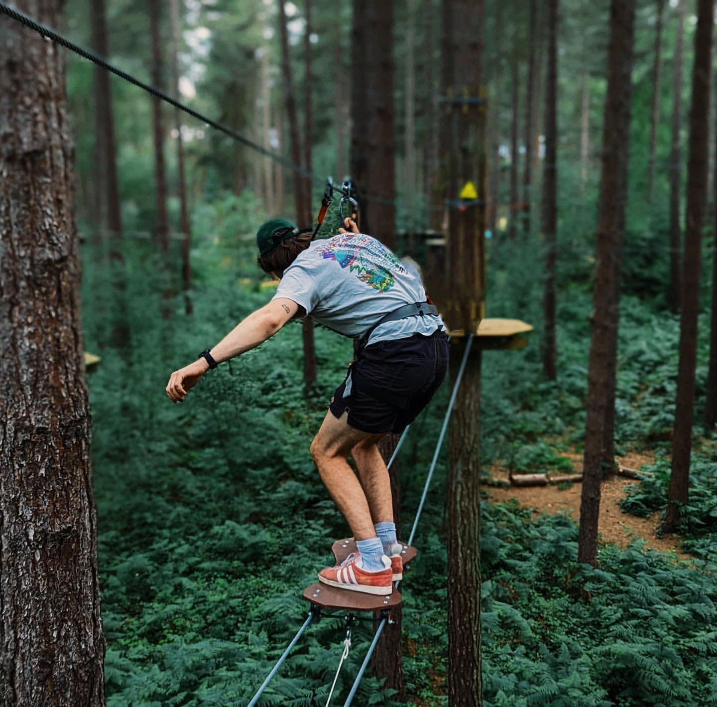 Man in grey shirt on Go Ape Challenge Plus crossing