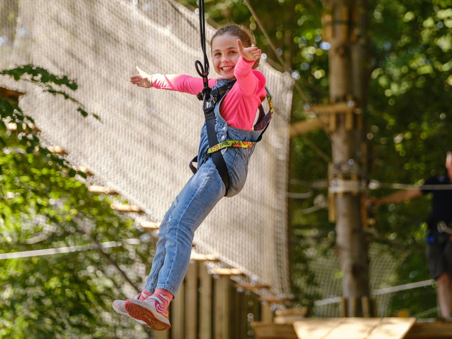 Young person smiles on a zipline.
