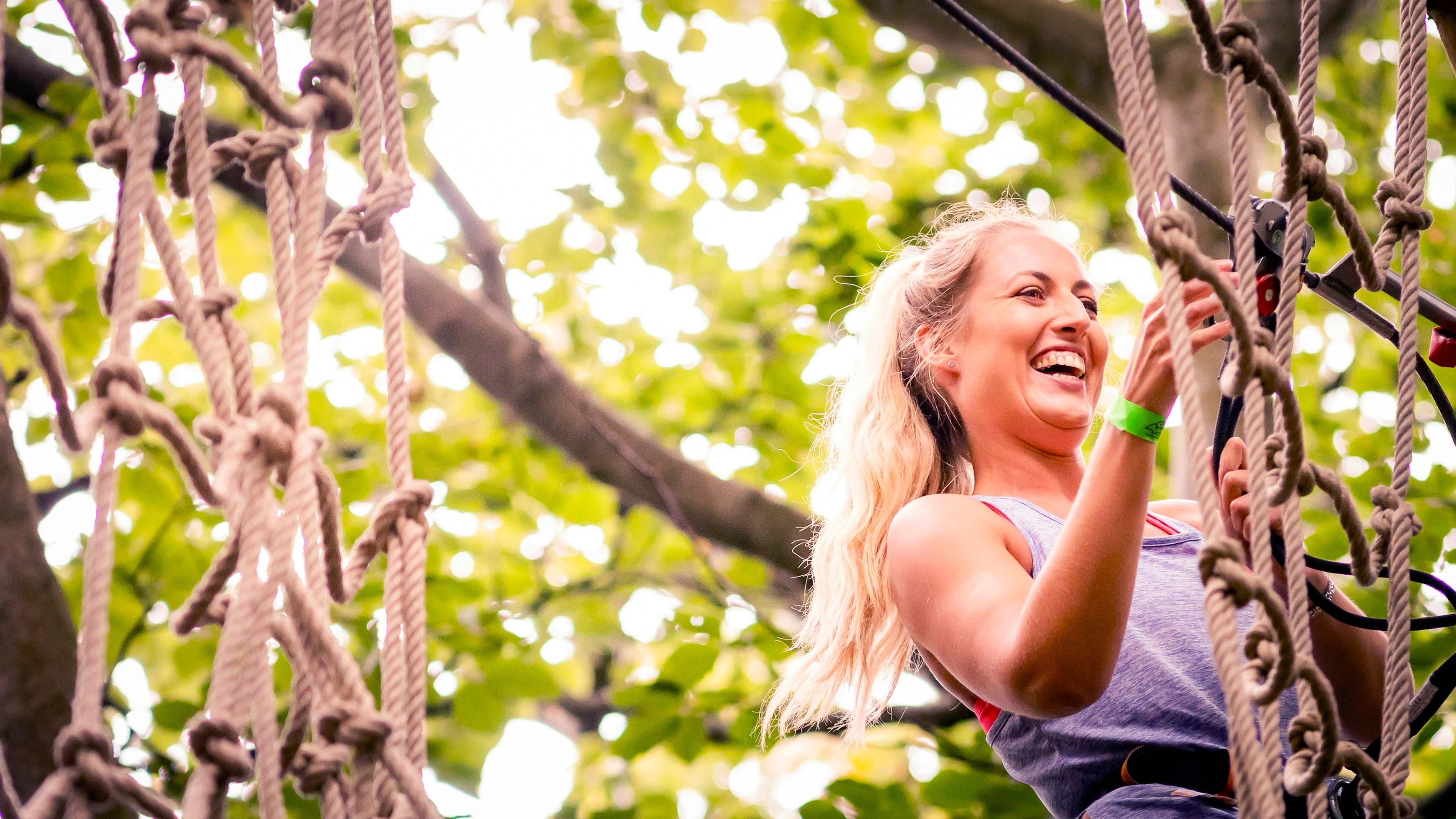 Person laughing while climbing a cargo net.