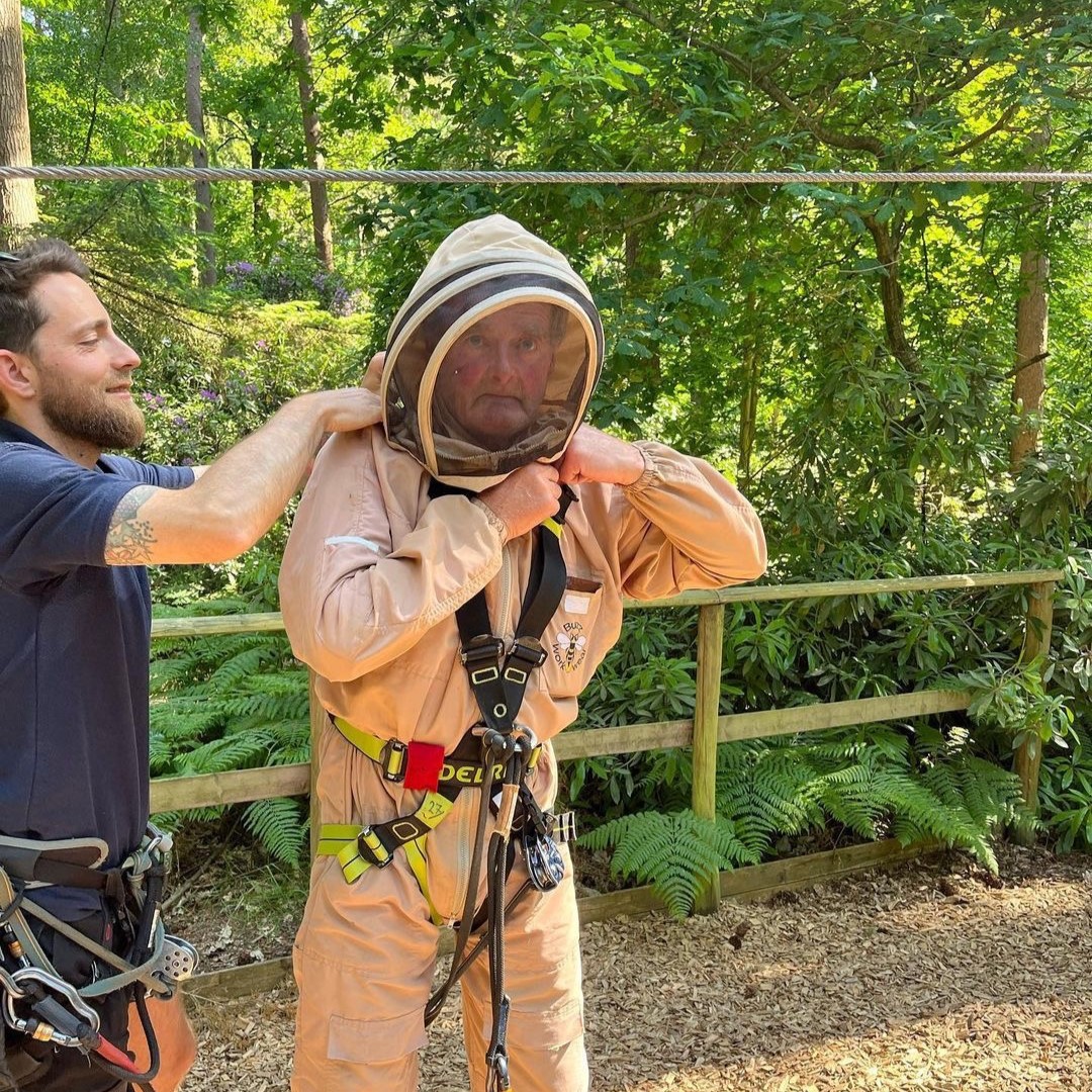 a bee keeper getting fitted into a Go Ape high ropes harness