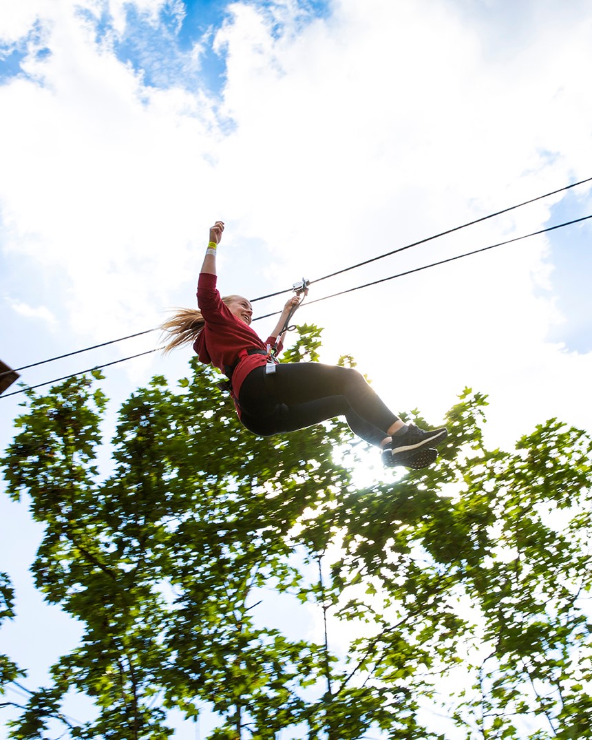 a girl having a fun time on a Go Ape zip wire, a great day out if you're searching for zip wire near me