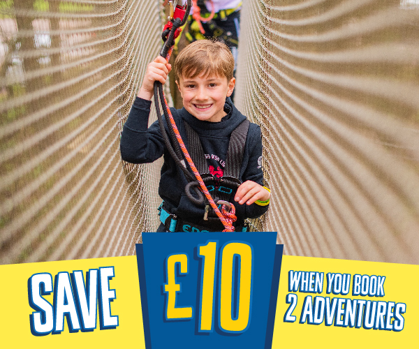 A boy smiles as he negotiates a high ropes crossing in the forest with the text save 10 pounds when you book two adventures