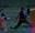 A group of colleagues play Archery Tag after dark illuminated by colourful lights