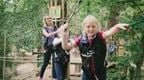 A girl in a red top on a Go Ape Treetop Adventure crossing at Go Ape Forest of Dean