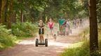 A group of people riding Go Ape Forest Segways through the forest