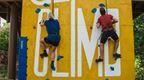 Man and woman climbing up Go Ape Speed Climbing wall at Alexandra Palace.