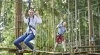 Girl in grey on stirrups on Go Ape Treetop Challenge experience 