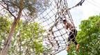 Girl in pink on Go Ape Treetop Challenge Tarzan Swing 
