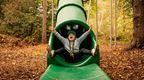 girl in grey hodie at the bottom of green slide at Go Ape Black PArk