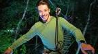 A man climbs through a Go Ape course at night