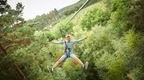 A man on a Go Ape zip wire in the forest