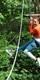 Woman in orange jumper on Go Ape Treetop Challenge zip line