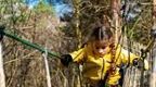 girl in yellow coat on Go Ape crossing 