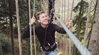 Man in a black hoodie on a Go Ape crossing