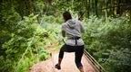 Woman in grey hoodie taking off on Go Ape Buxton zip line in forest | Outdoor activities Buxton | things to do in Buxton