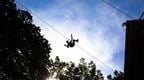 person on zip line against sky