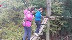 A girl in pink and a woman in blue on a Go Ape Treetop Adventure course