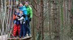 Young boy in orange and father on Go Ape Treetop Challenge crossing