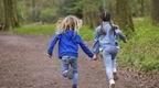 Children running down a forest pathway 