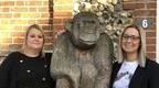two women smiling next to wooden ape outside Go Ape office