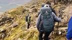 Group of adventurers climbing down a mountain 