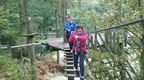 A girl in a pink hoodie and a woman in a blue hoodie on a Go Ape crossing