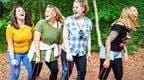 Four women in the forest laughing doing team building exercise
