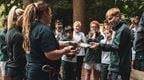A group of children receiving Go Ape certificates ona  trip with their boarding school