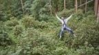Man on zip wire with arms in the air
