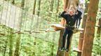 A girl in black on a Jungle Crossing at Go Ape Grizedale