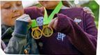 Two chilren holding up Go Ape medals