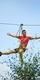 A man enjoying his Go Ape annual pass riding a zip wire over a forest