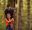  A boy wearing an orange top walks out on to a Go Ape Treetop Adventure crossing in the forest, supervised by his dad on a family day out for half term