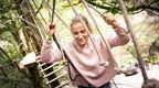 A woman on a Go Ape high ropes course at Temple Newsam for her team day near Leeds