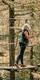 A woman on a Go Ape crossing in the forest