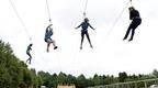 four adults ziplining on Go Ape Chessington four person zip wire | fun date ideas in London