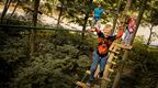 Young boy and family in red coat on Go Ape Adventure crossing