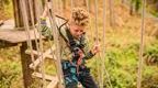 A boy on a Go Ape high ropes adventure crossing at Go Ape Salcey Forest near Northampton and Milton Keynes