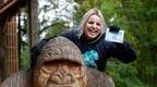 woman laughing on top of Go Ape gorilla sculpture holding Go Ape certificate  | How to plan a hen do