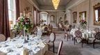 A formal dining room with a stunning fireplace, perfect for conferences at Coombe Abbey hotel in the Midlands